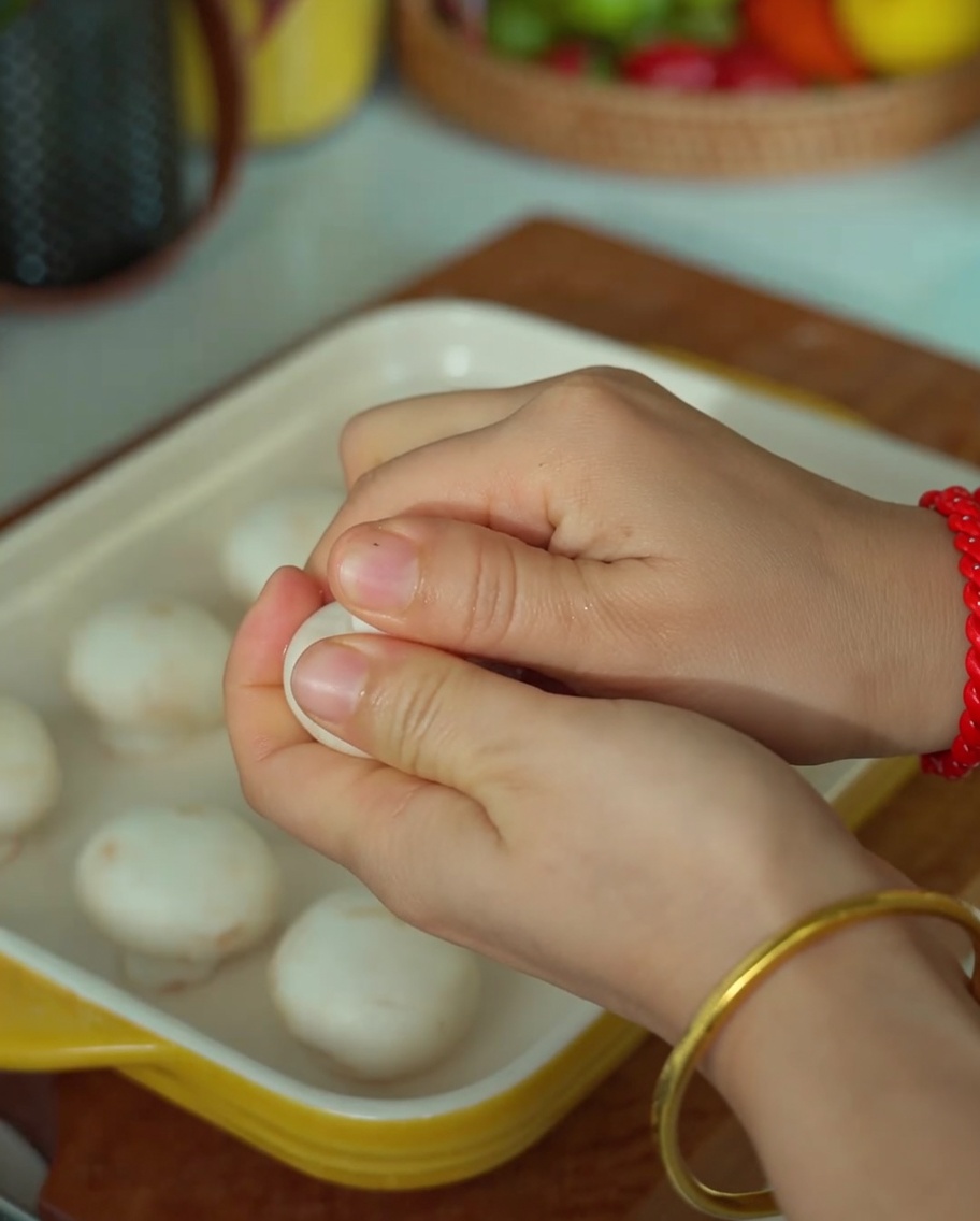ホワイトマッシュルームの軸を取り、中心をくり抜く手元。