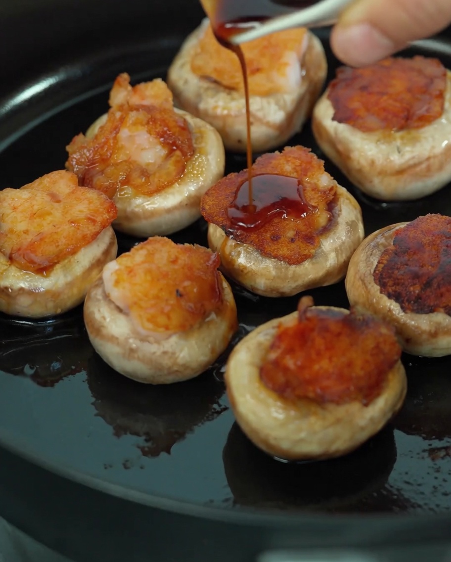 醤油とマッシュルームの旨味汁をかけて蒸し焼きにする様子。