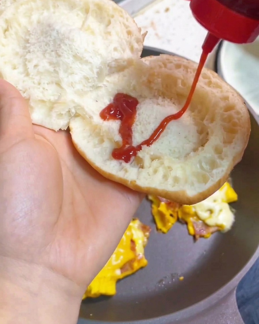 トーストしたバンズにトマトケチャップをかけている様子。