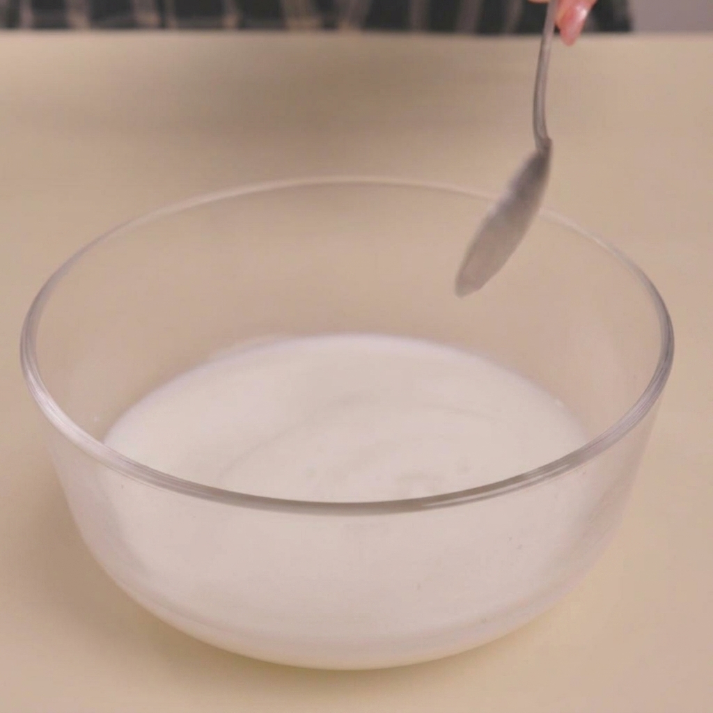ボウルに入れた牛乳にビネガーを加え、とろみがついて分離した状態。