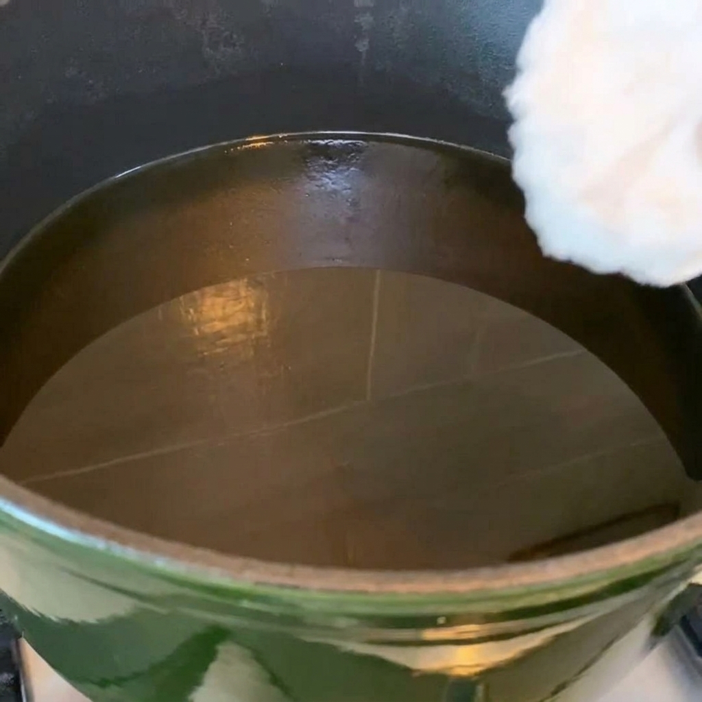 熱した油で揚げているきつね色の鶏手羽先