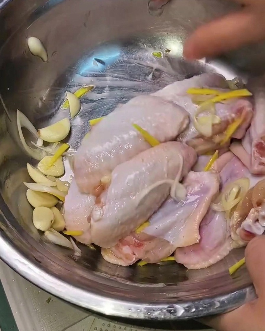 手羽先と香味野菜を手でしっかりと揉み込んでいる様子。