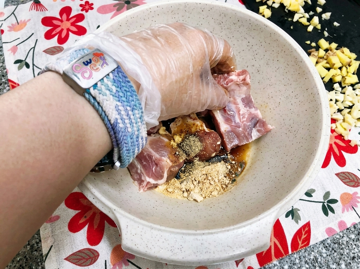 すりおろしたてのりんごペーストを、下味をつけたポークスペアリブにかけている様子。