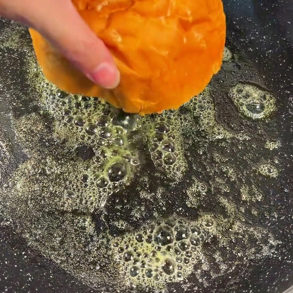 バターを溶かしたフライパンで、バーガーバンズの切り口を黄金色になるまでトーストしている様子。