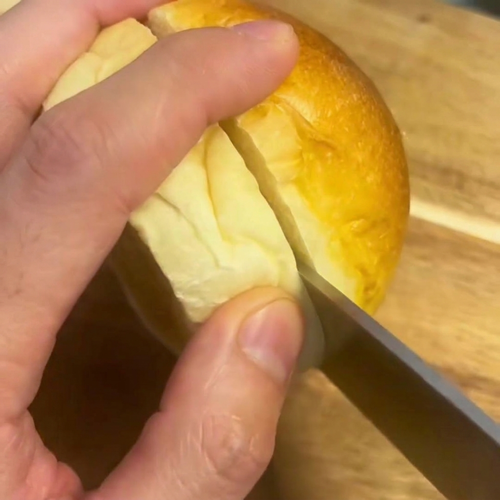 まな板の上でバーガーバンズを半分に切っている様子。