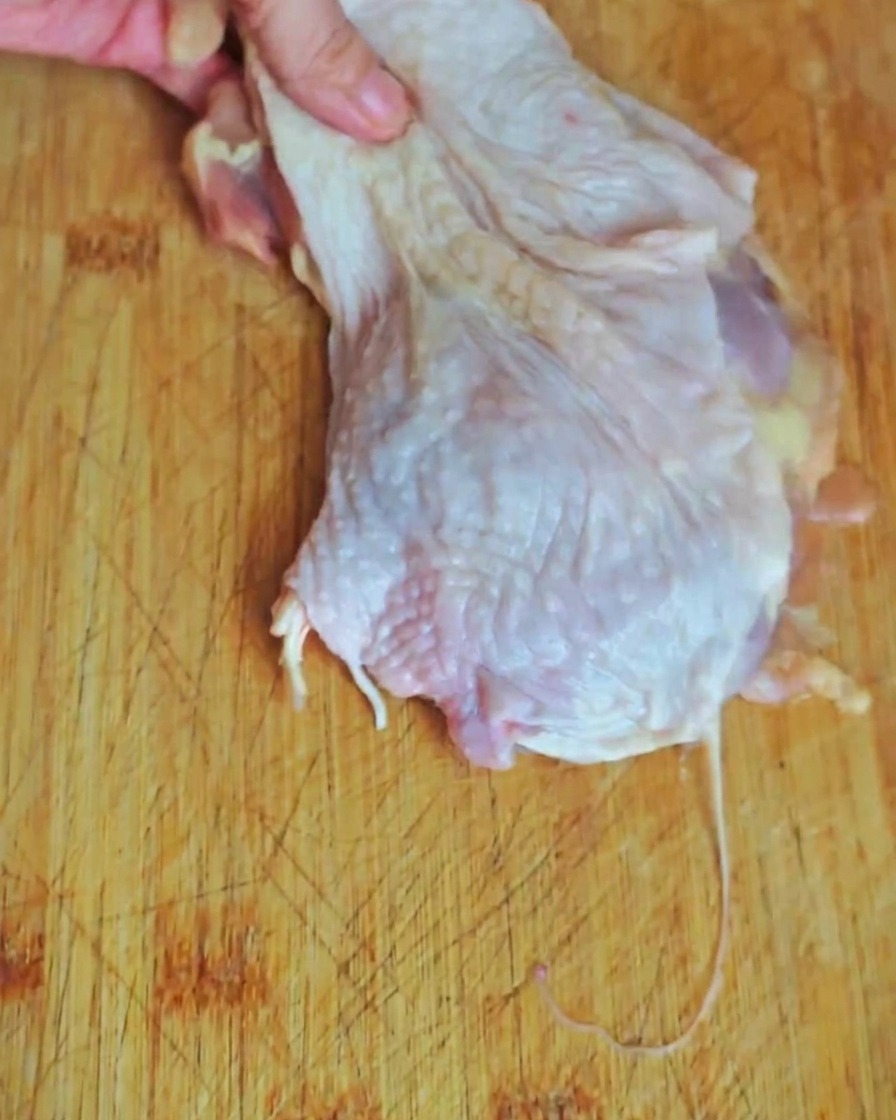 まな板の上で鶏もも肉を食べやすい大きさに切り分けている様子。