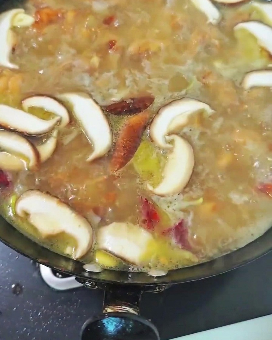 煮立っているスープの中で椎茸を煮ている様子。
