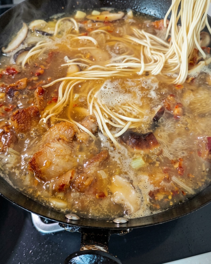 鶏肉と椎茸のスープの中に、麺を投入する様子。