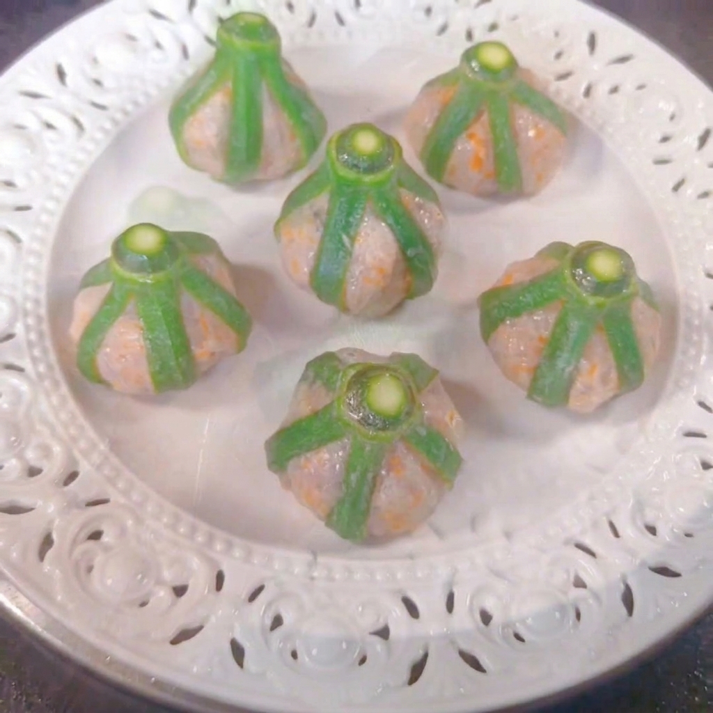 蒸し器の中の白いお皿に並べられた6つのオクラと海老の蒸し物