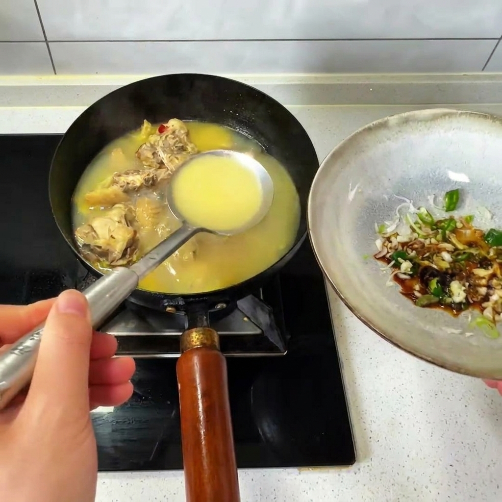 中華鍋から熱々のチキンブロスを、調味料が入ったボウルに注いでいる様子。