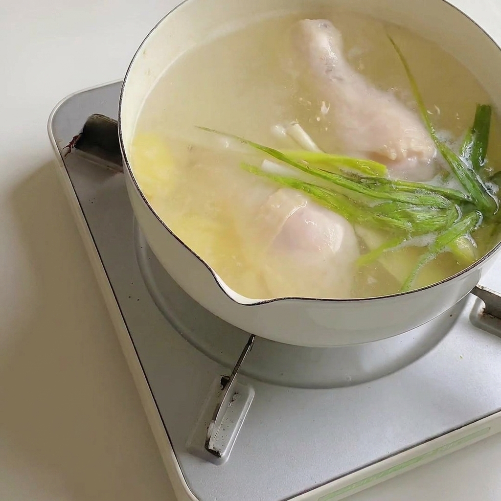 下茹でした鶏肉が入った鍋にラーメンの粉末スープを入れている様子。
