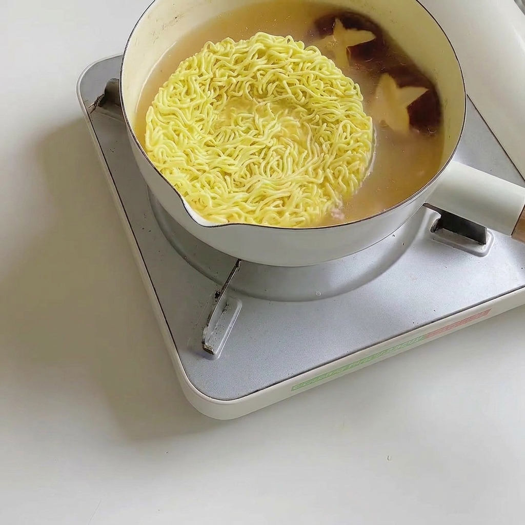 麺と一緒にチンゲン菜を煮ている様子。