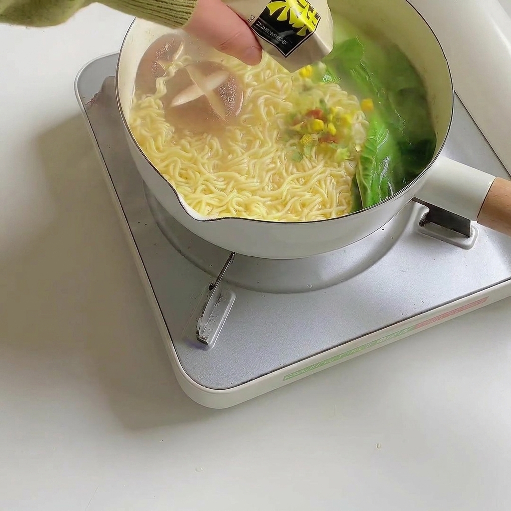 完成したラーメンにかやくをトッピングしている様子。
