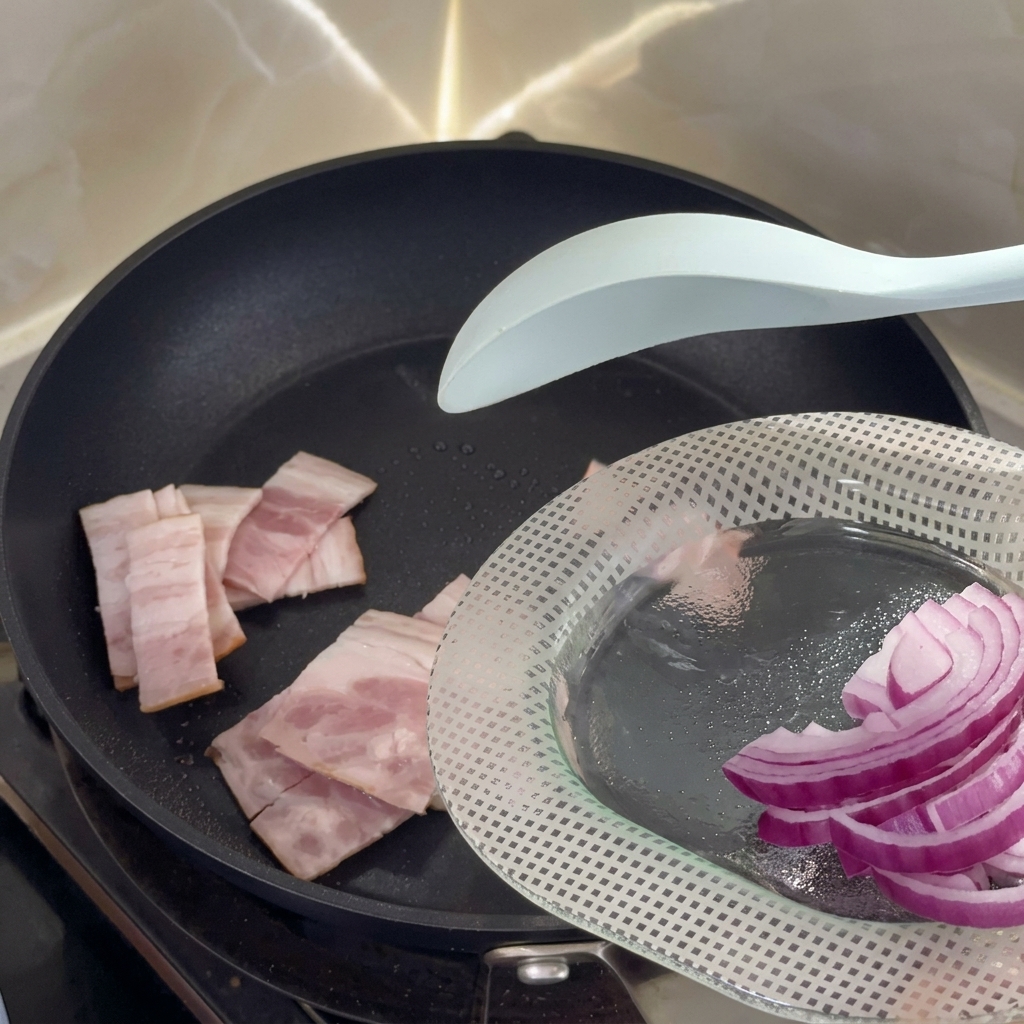 フライパンでベーコンを焼いている様子