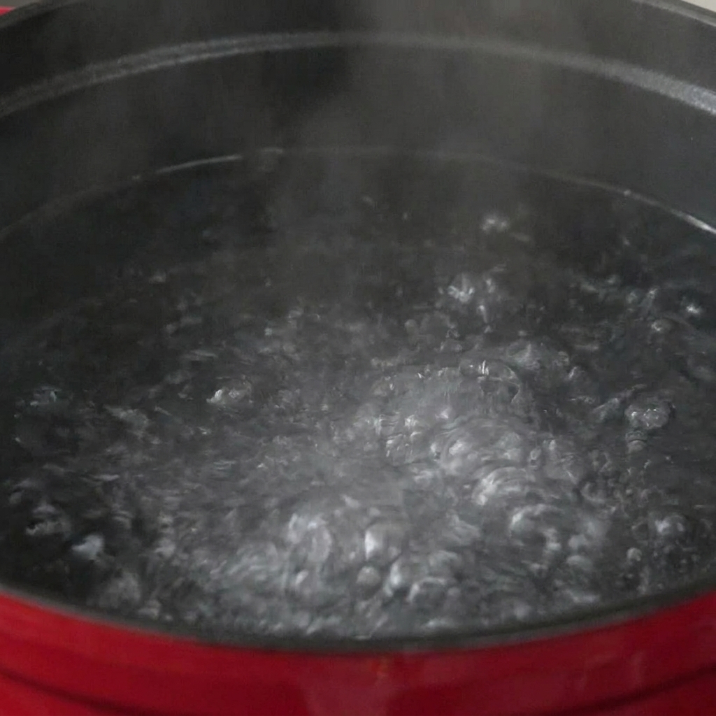 沸騰して泡立つ大きなお鍋の中で茹でられているパスタ。