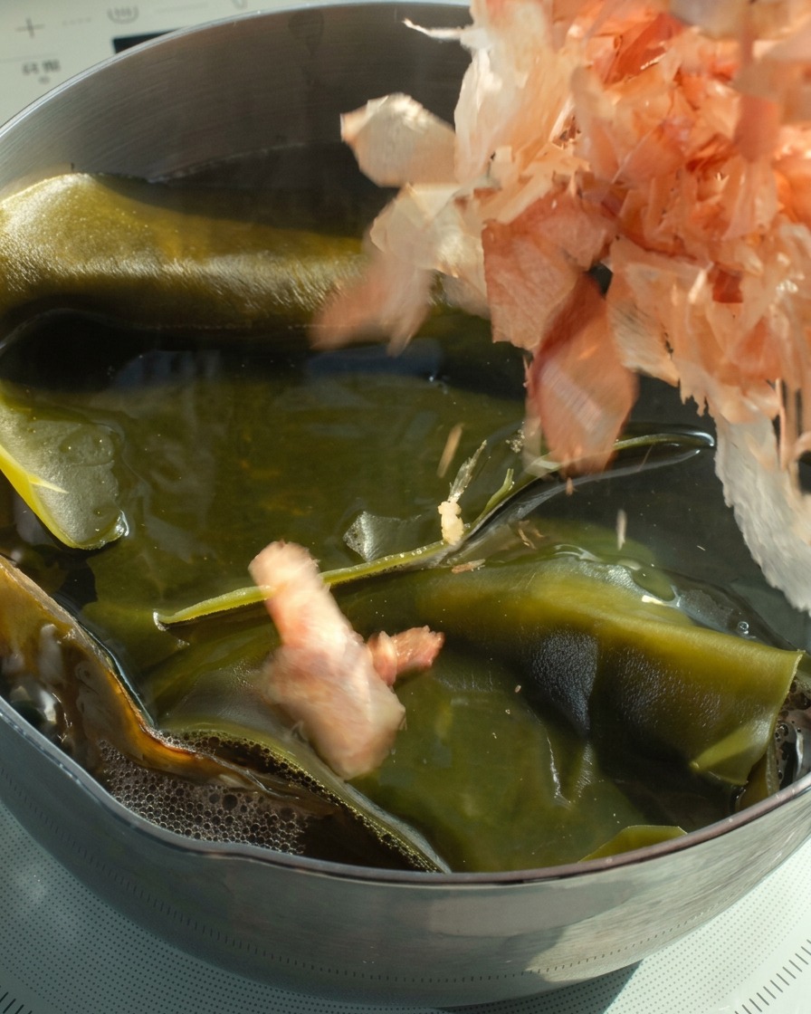 熱い昆布だしにかつお節を入れている様子。