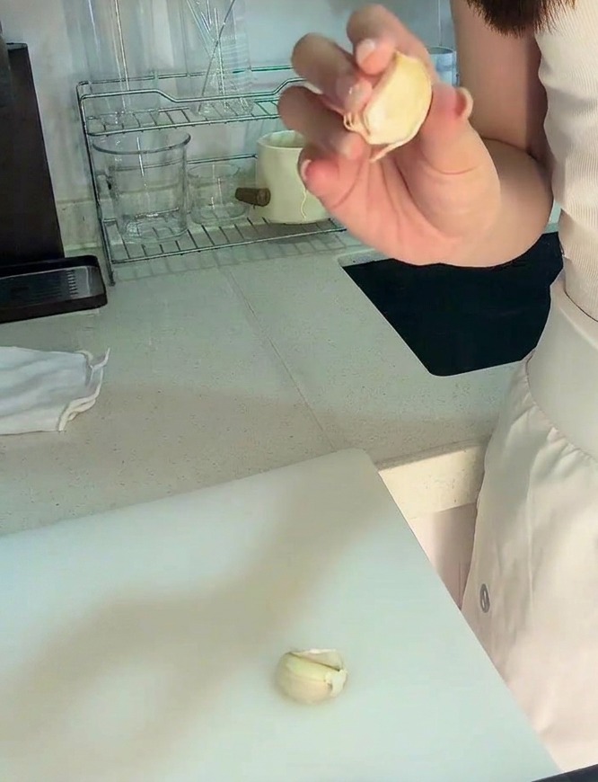まな板の上で、皮をむいたにんにく一片と、刻んだにんにくが見える様子。