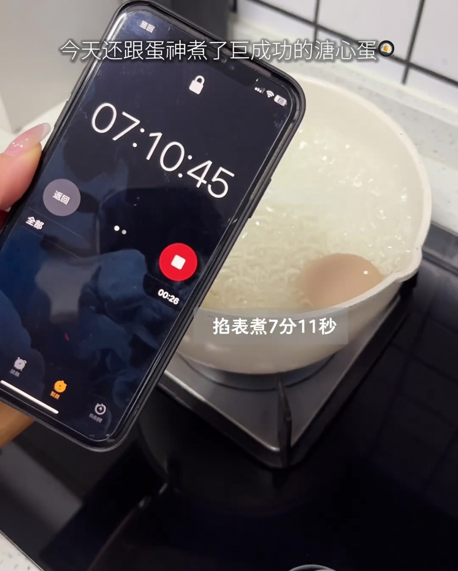 鍋で茹でられている卵と、タイマーを表示するスマートフォン。
