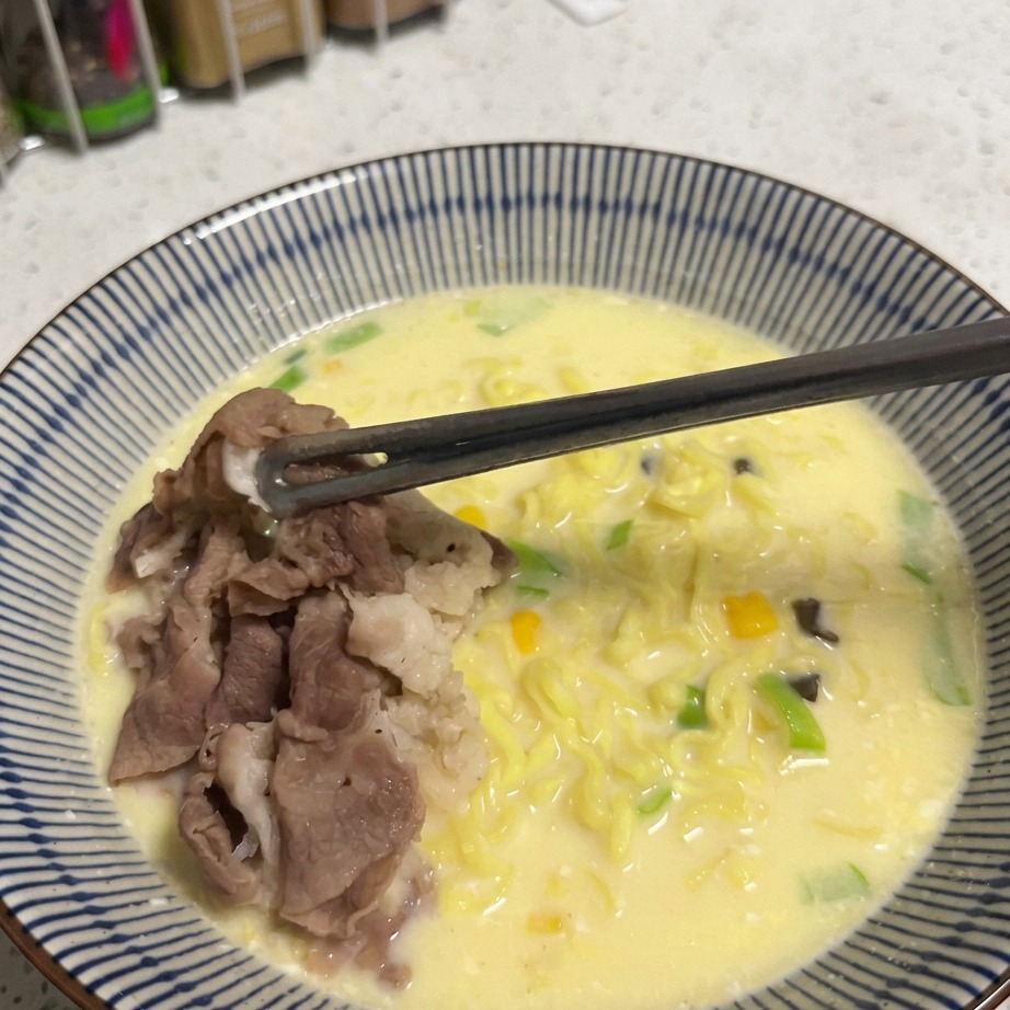 ラーメンの上にコーンが乗せられる瞬間。