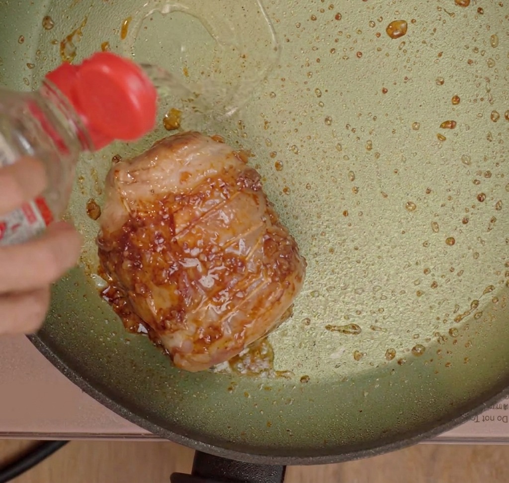 調味料を加えてチャーシューを煮込んでいる様子