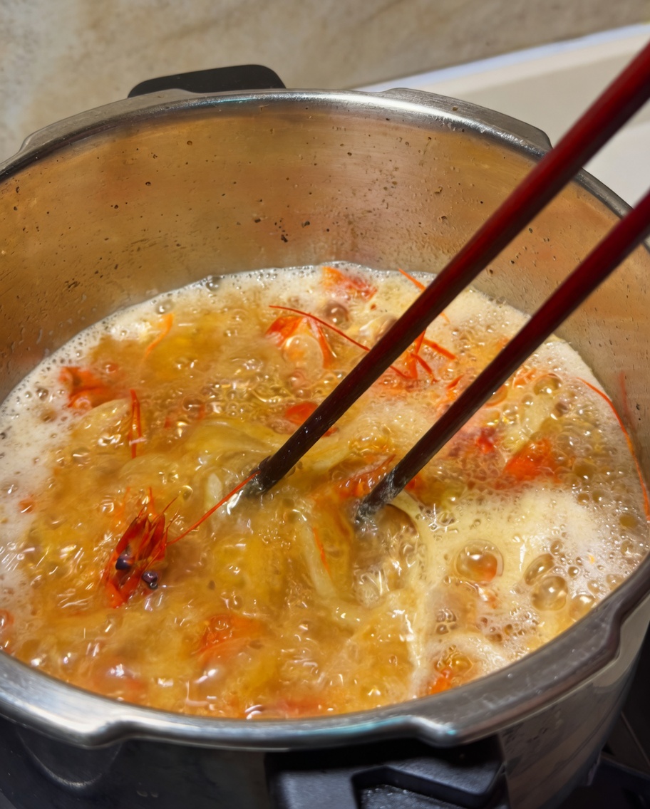 煮汁にバターを落とし、菜箸で溶かす様子。