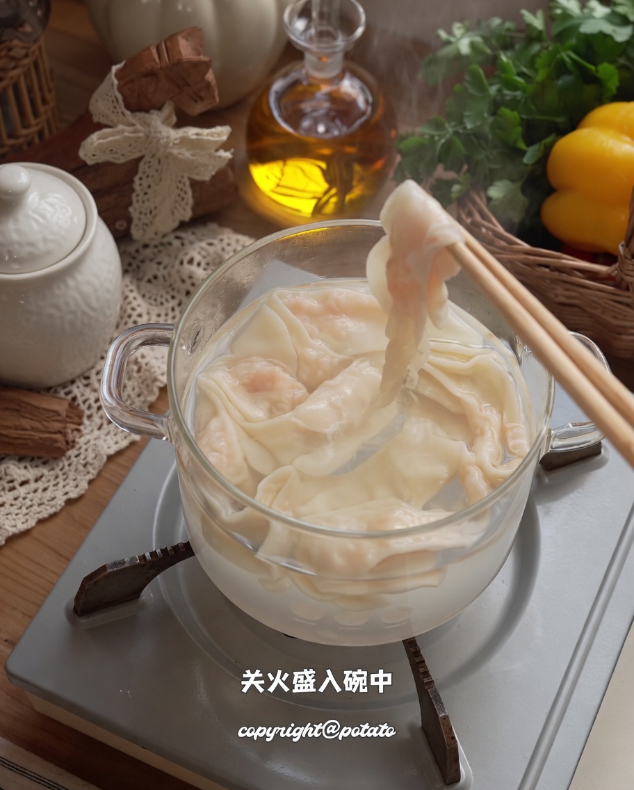 箸を使って鍋から茹で上がった麺を器に移している様子。
