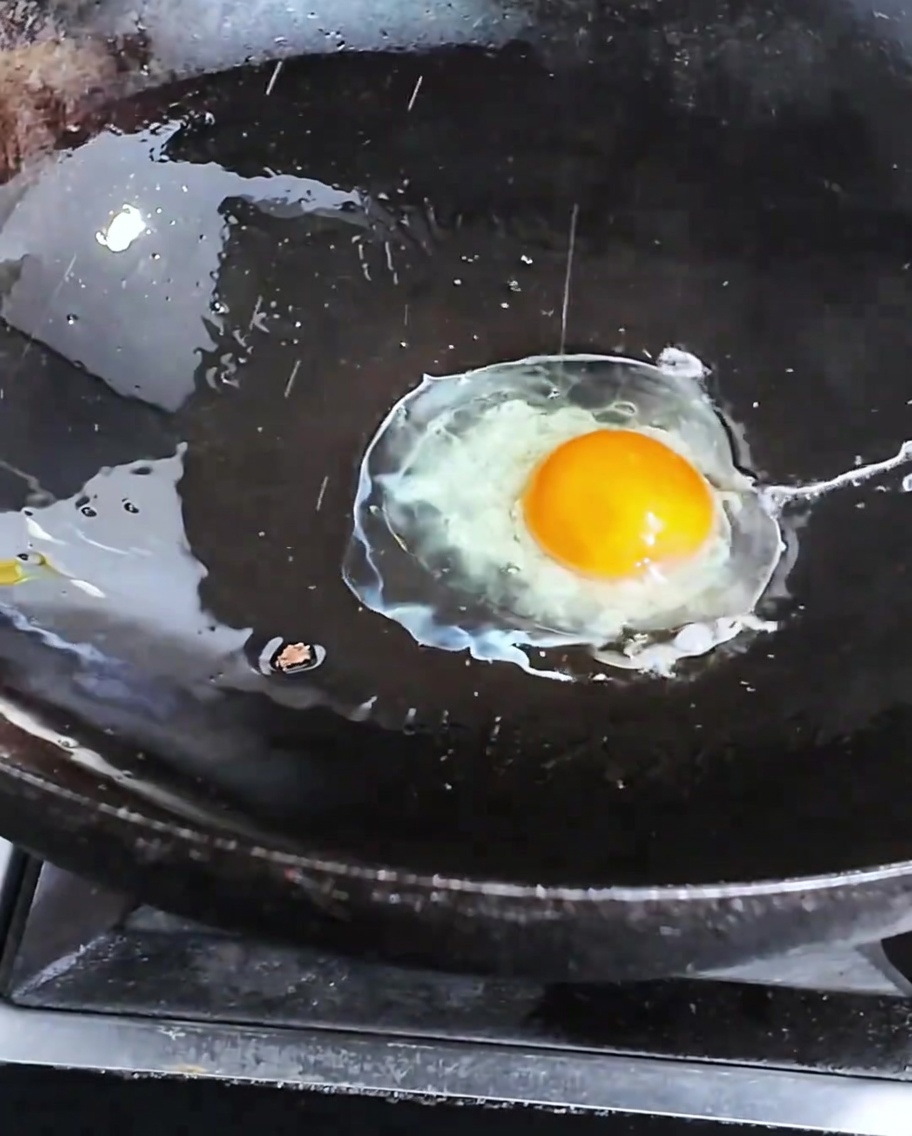 熱したフライパンで目玉焼きを焼いている様子。