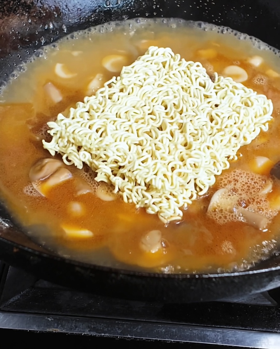 海老スープの中で麺と目玉焼きが煮えている様子。