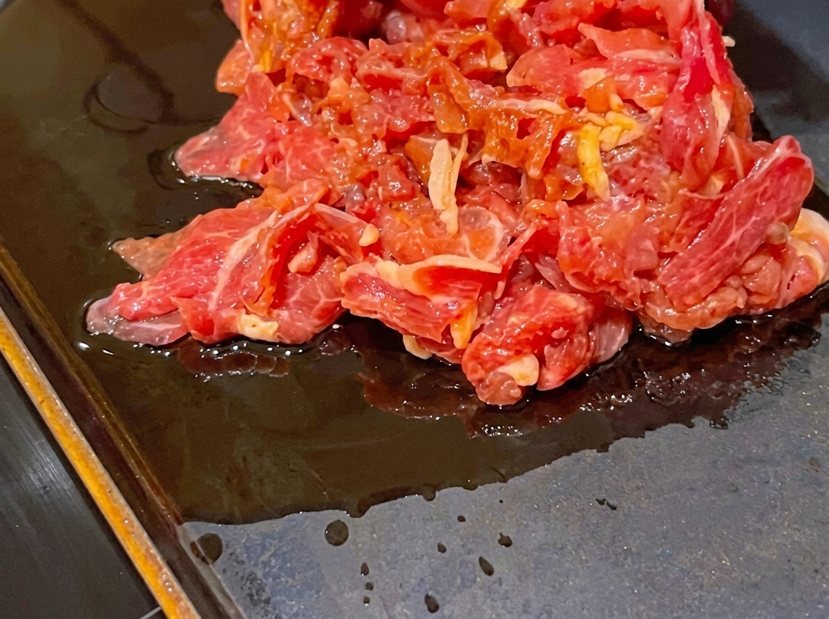 熱したフライパンでマリネした牛肉を焼いている様子。
