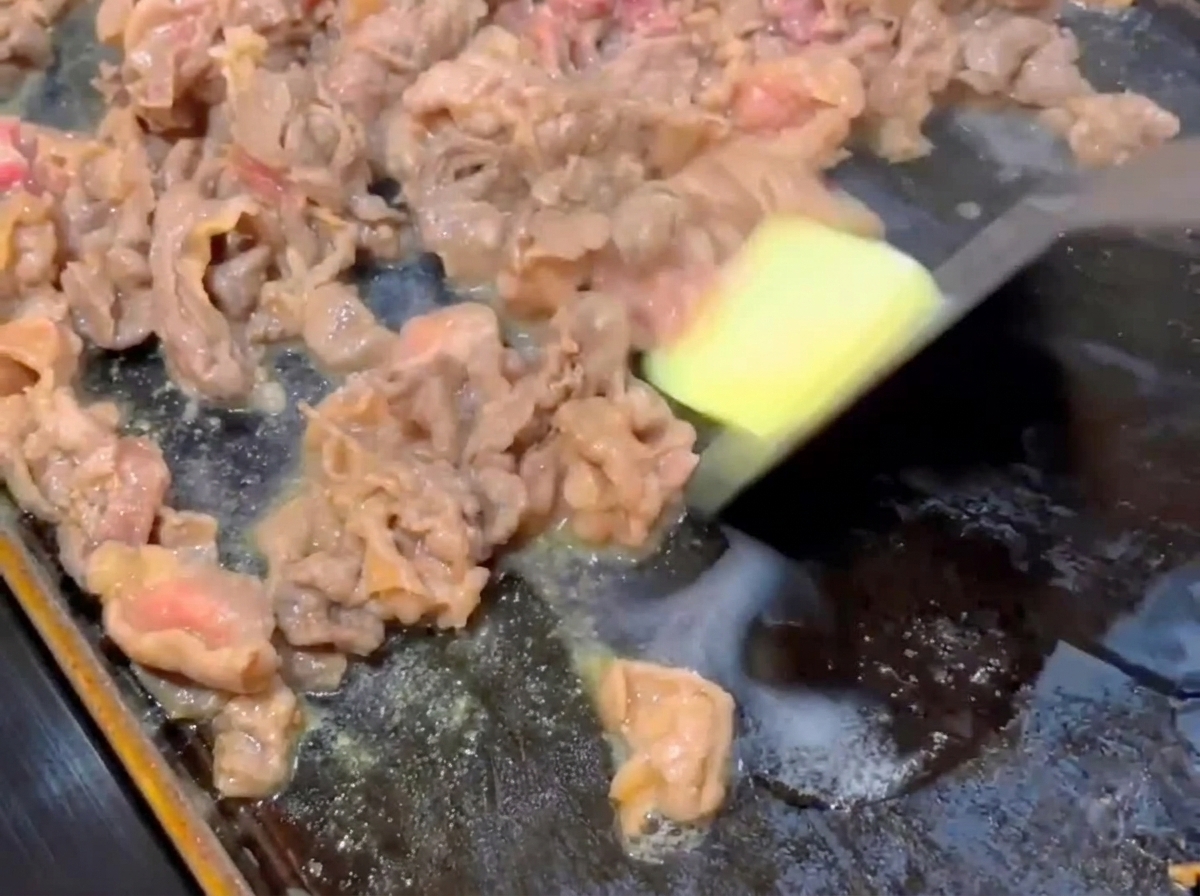 焼いている牛肉にバターを加えている様子。