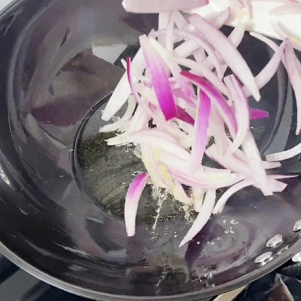 中華鍋で炒められる赤玉ねぎのスライス。