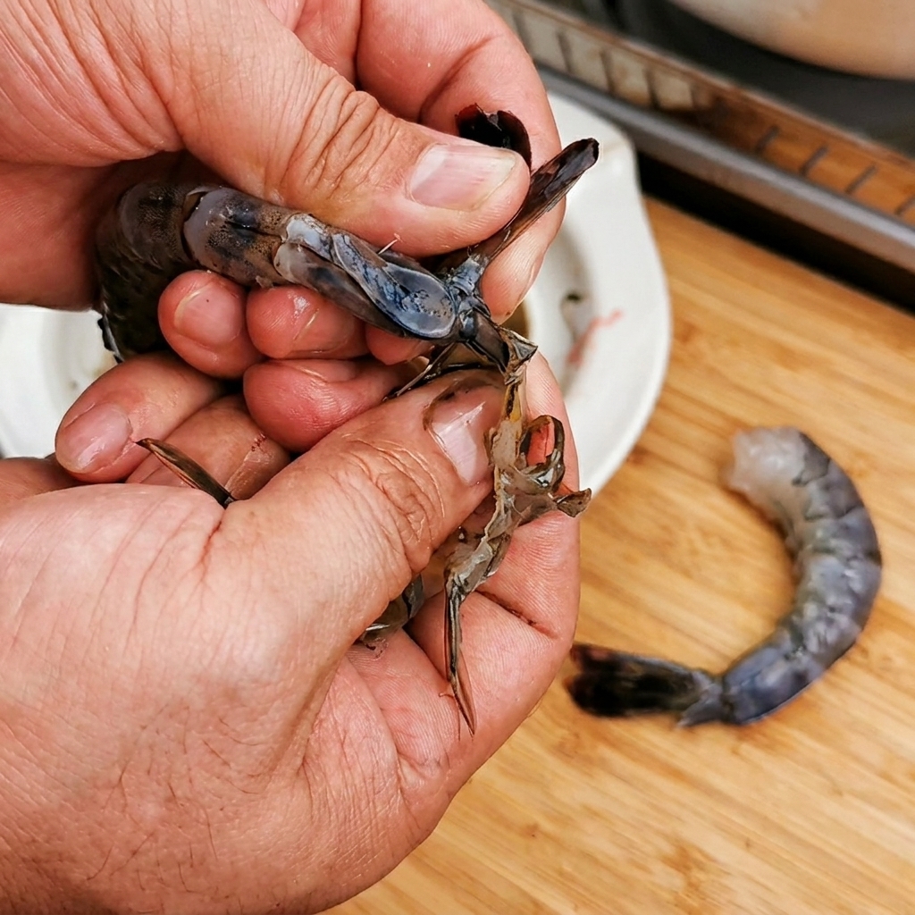 海老の殻を剥き、尾を残した状態で並べている様子。
