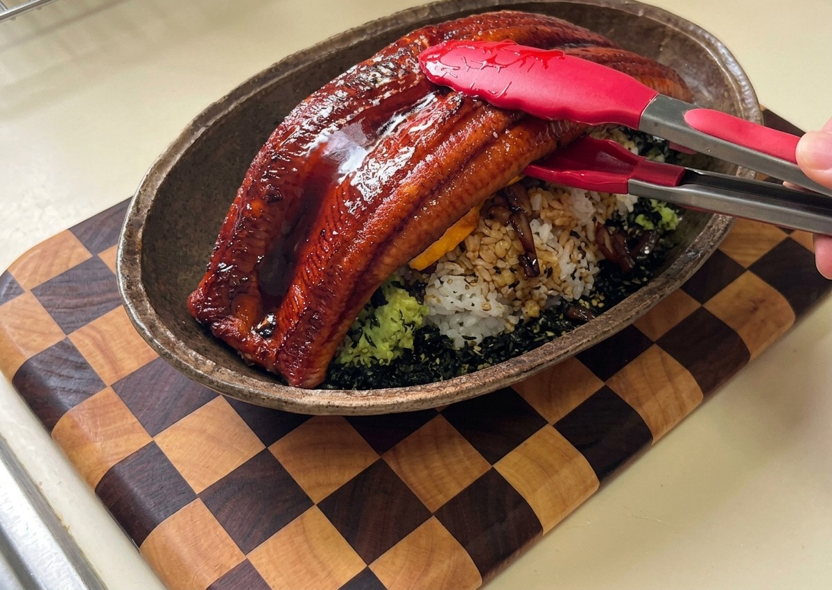 鍋で醤油ベースのソースを煮詰め、はちみつを加えている様子。