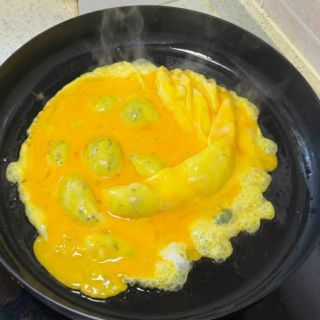 木べらを使ってフライパンの中で卵を優しくかき混ぜる様子。