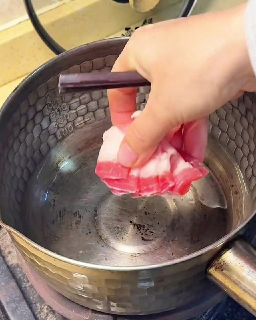 鍋で豚バラ肉を炒め、脂が出てきた様子。