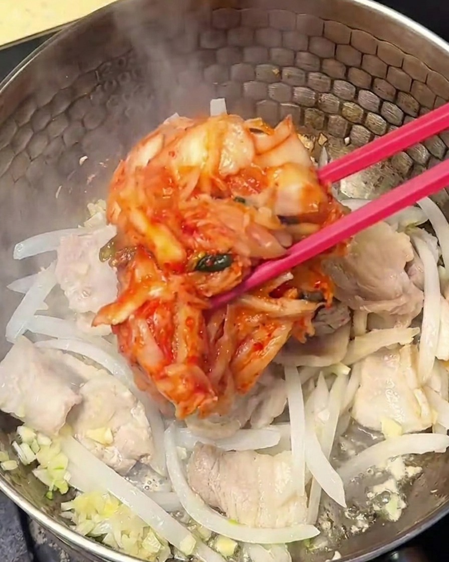豚肉と玉ねぎと一緒にキムチを炒めている様子。
