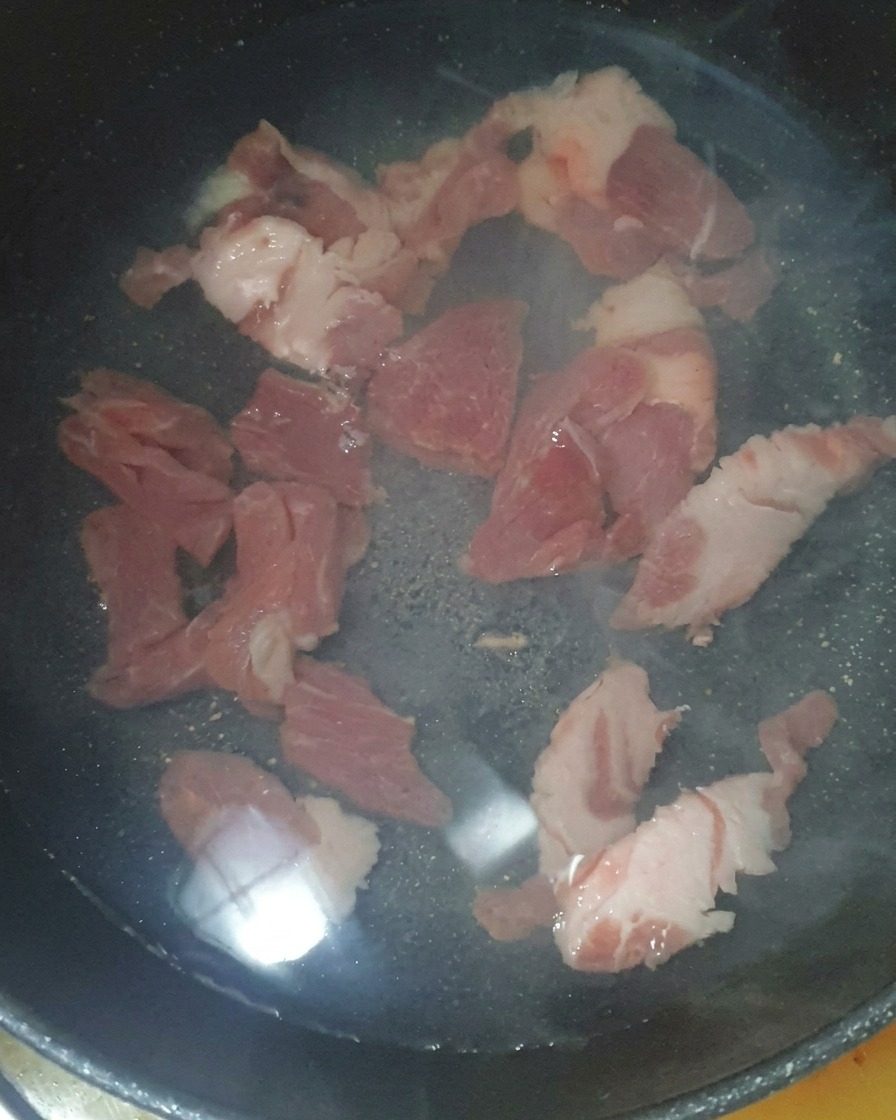 鍋に水と豚肉、アミの塩辛を入れて煮込んでいる様子。