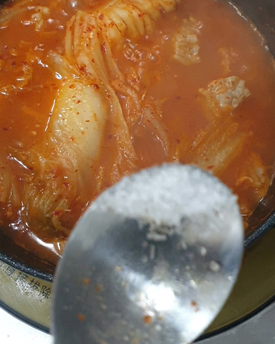 鍋に砂糖と味の素を加えている様子。
