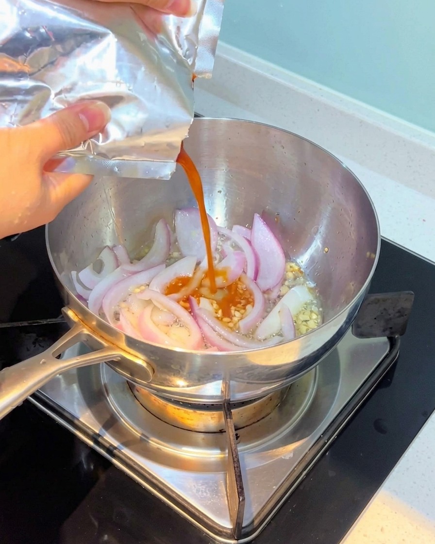 炒めた香味野菜にキムチを加えている様子。