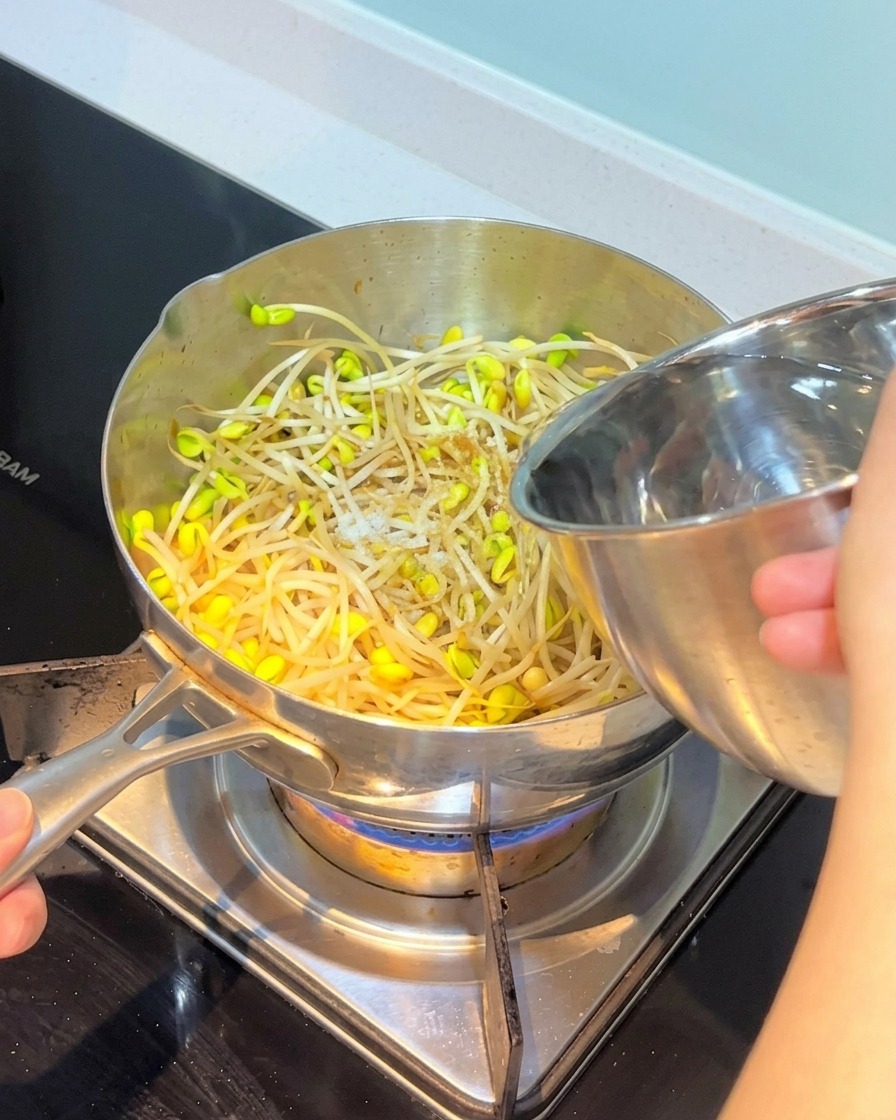炒めた野菜の中に水を注ぎ入れている様子。