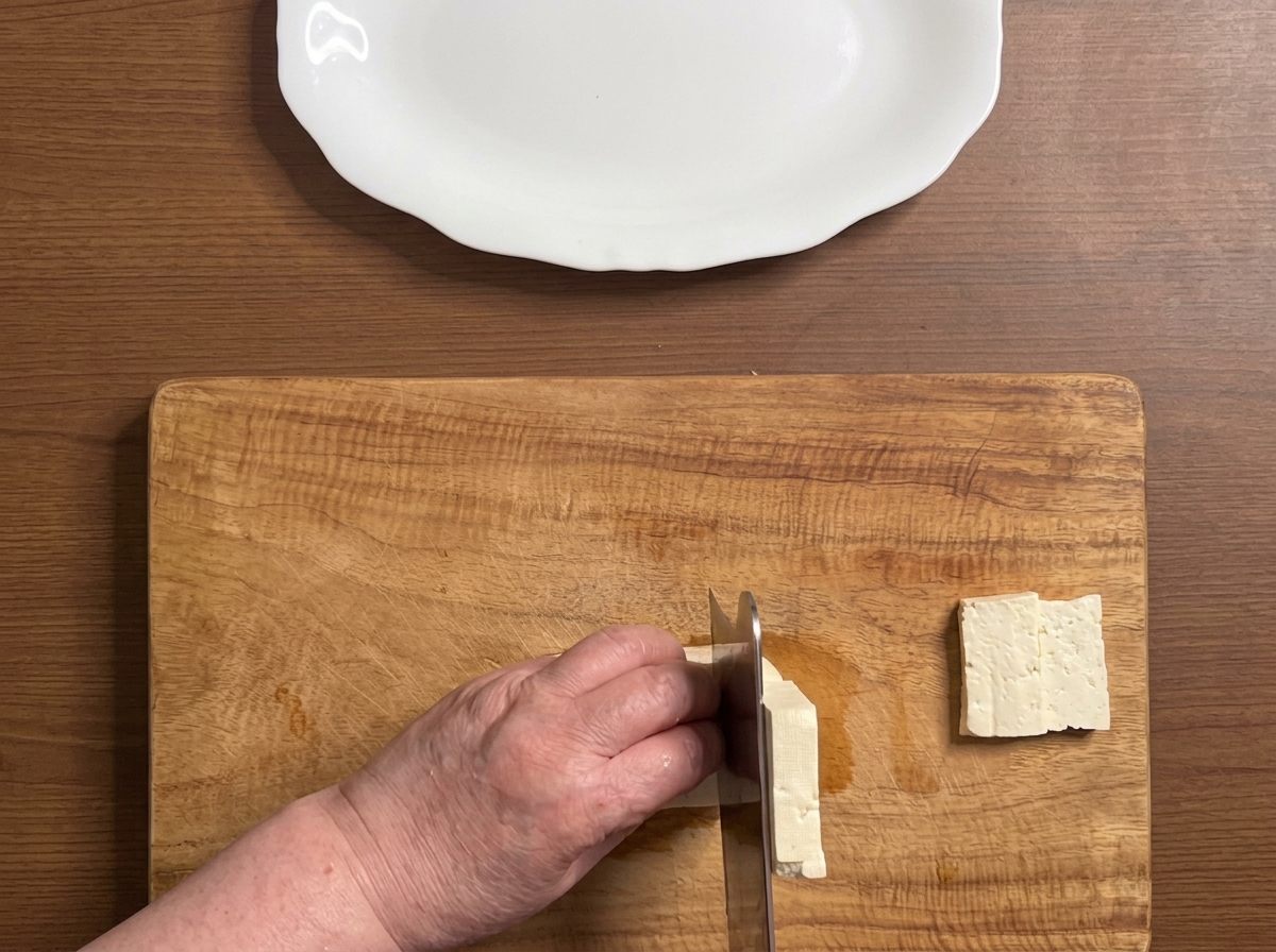 まな板の上で、豆腐を厚めに均等な大きさに切っている様子。