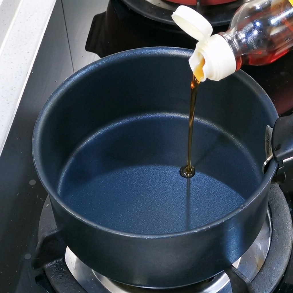 鍋にごま油を注ぐ様子。