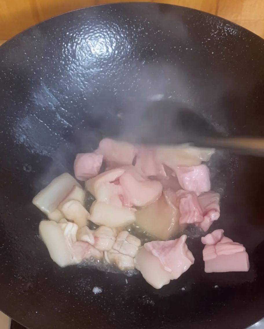 熱した中華鍋で豚バラ肉を香ばしく炒めている様子。