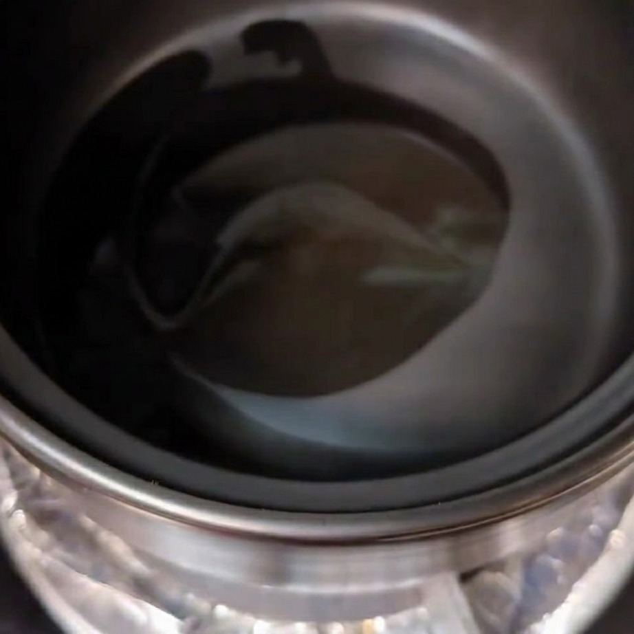 土鍋にサラダ油とごま油を垂らし、中火で熱している様子。