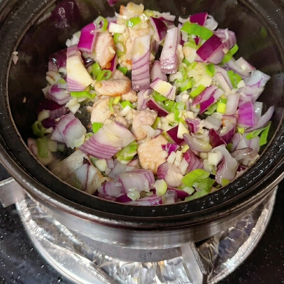 コチュジャンと粉唐辛子が、牛肉と野菜の混合物に混ぜ込まれている様子。
