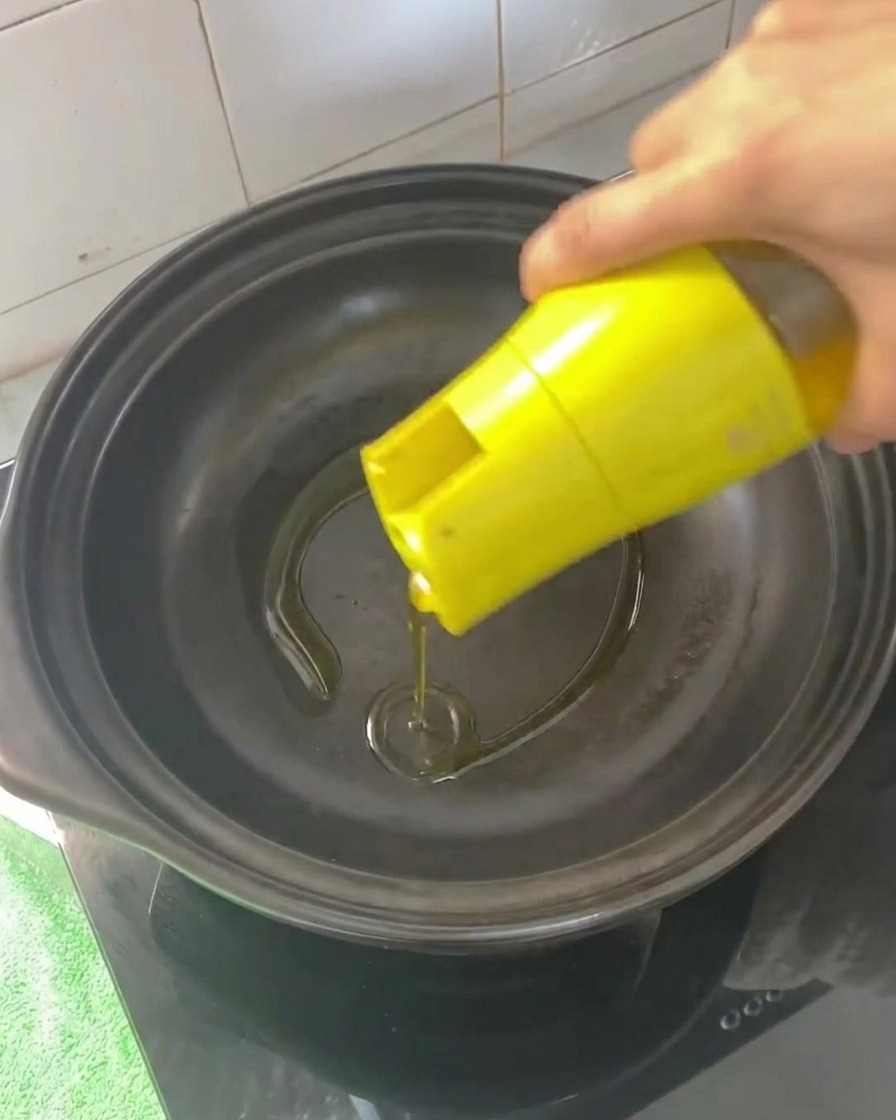 熱した土鍋に油を注いでいる様子。