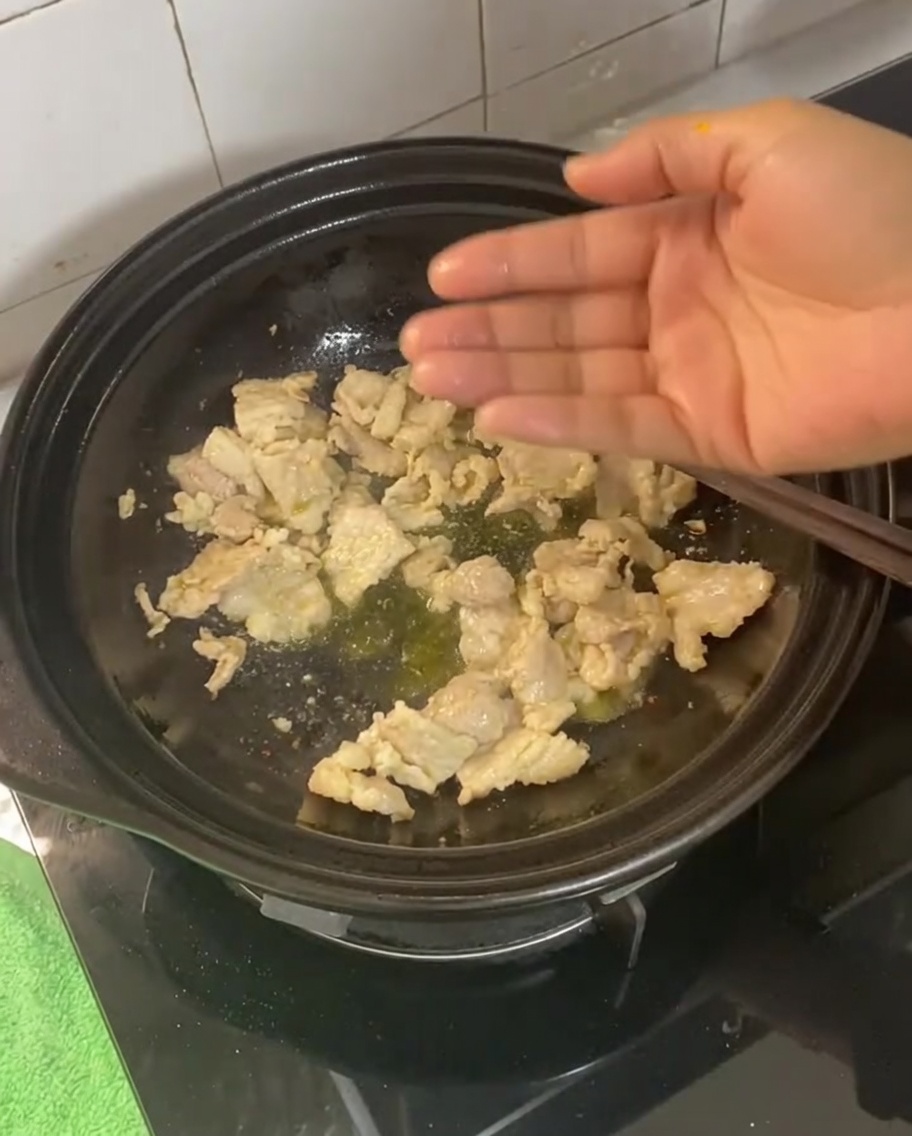生姜、ニンニク、ネギ、唐辛子を豚肉と炒めている様子。