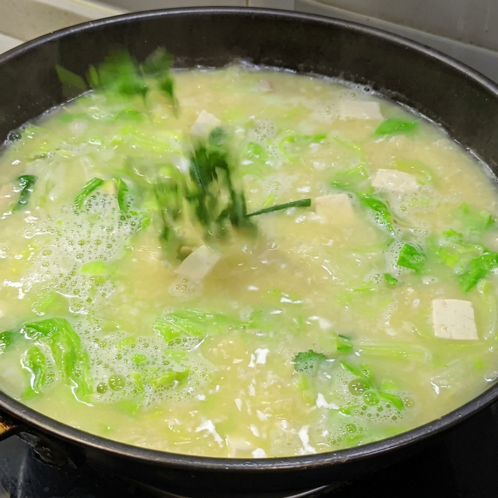 沸騰しているスープに水溶き片栗粉を加え、とろみをつけている様子。