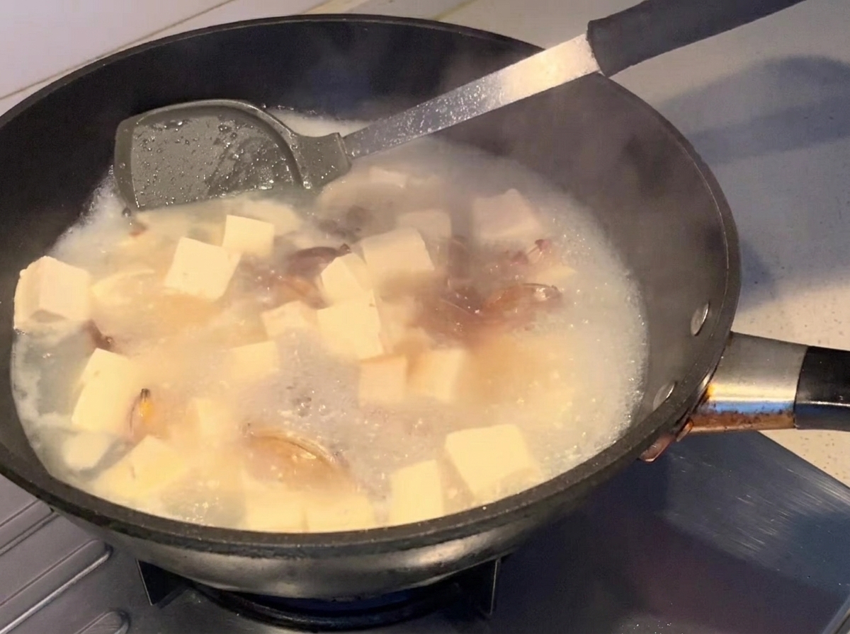 スープに醤油を回し入れている様子。
