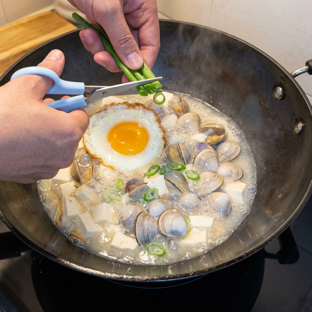 スープに新鮮な青ネギを散らしている様子。